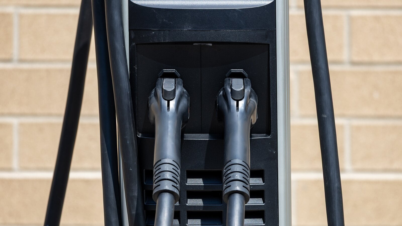 Two electric vehicle charging plugs on a charging station